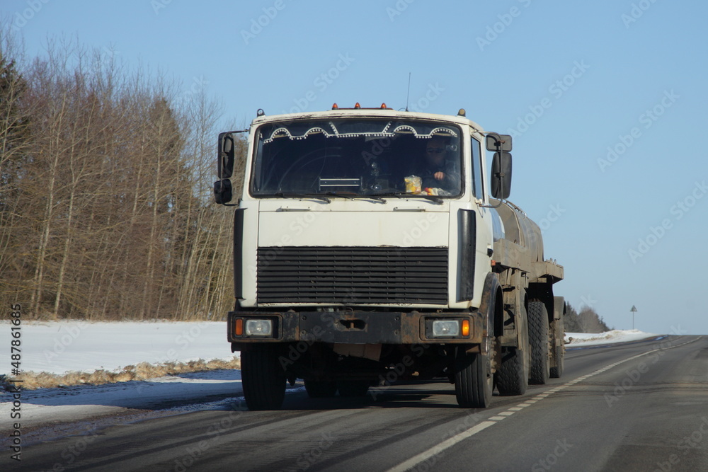 Barrel truck on winter road in Russia. Front view. Liquid cargo transportation logistics.