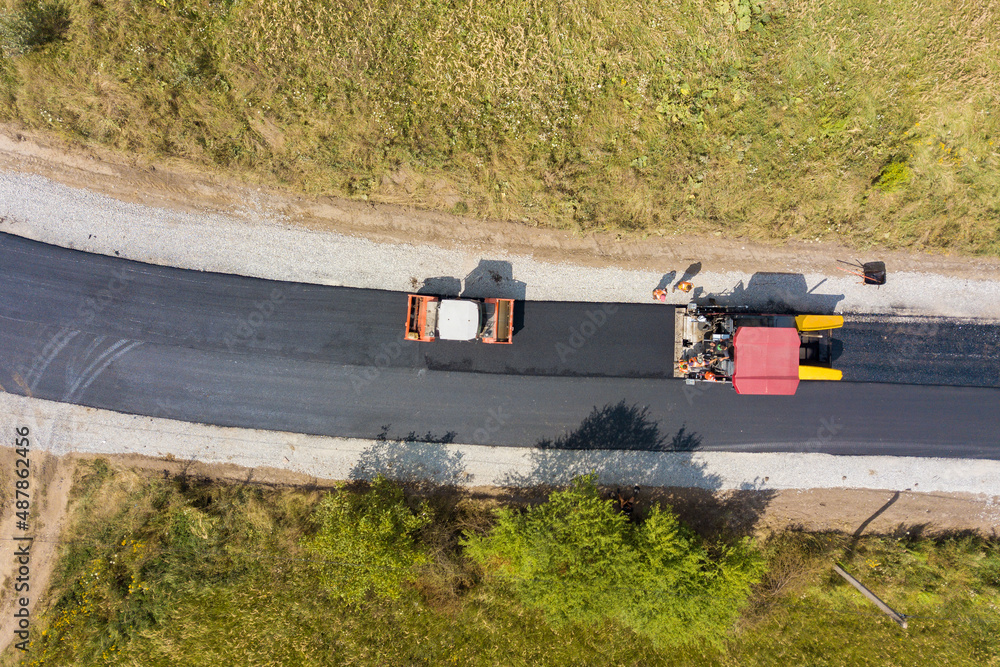 Fototapeta premium Aerial view of new road construction with asphalt laying machinery at work