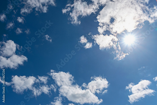 bright summer sun against the background of white clouds and blue sky
