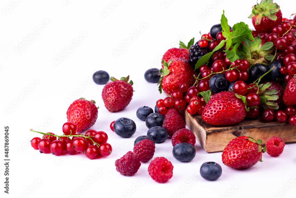 Ripe berries mixed assortment on wooden board on white background. Summer berries background. Cloce up image with copy space. Ripe berries mixed assortment on wooden board on white background. Summer berries background. Cloce up image with copy space.