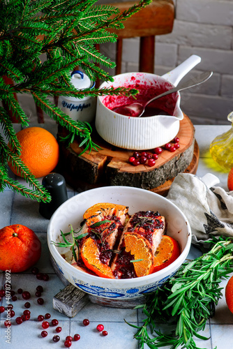 Baked salmon with tangerines in cranberry sauce in a white pan.style vintage