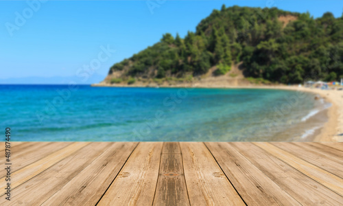Fondo de playa desenfocado con tabla de mesa en primer plano. Paisaje y mesa. Tablón y fondo de playa. Naturaleza.