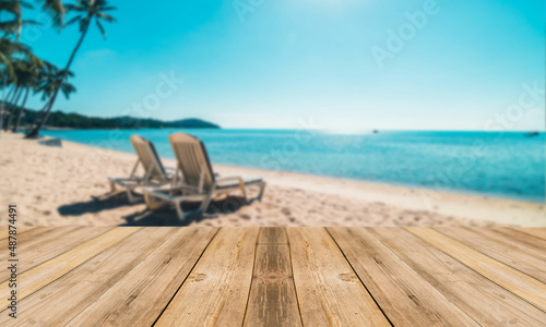 Fototapeta Naklejka Na Ścianę i Meble -  Fondo de playa con sillas desenfocado con tabla de mesa en primer plano. Paisaje y mesa. Tablón y fondo de playa. Naturaleza