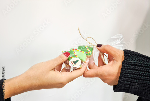  A packaged cookie present given from hands to hands. 