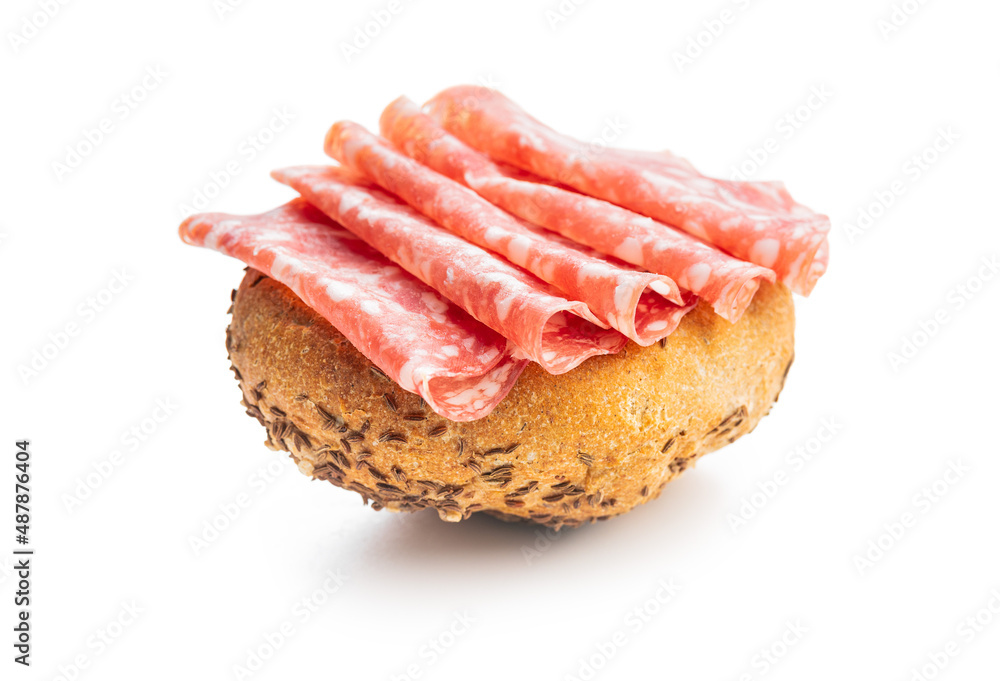 Bun with sliced salami isolated on white background.