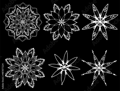 A set of vector mandalas. a set of hand-drawn round symmetrical ornaments, a white isolated contour. The mandala is a round flower stylized as a symmetrical pattern of petals with a white line on blac