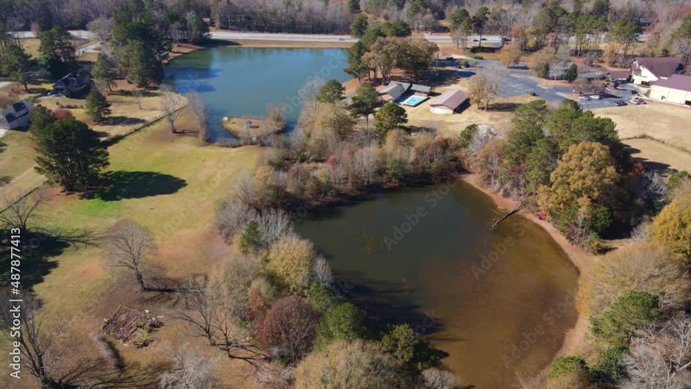 Aerial drone view circles brown lake toward a blue lake with road and traffic. Aerial drone view circles brown lake toward a blue lake with road and traffic.