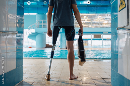 Stampa su tela Rear view of athlete with artificial leg in front of indoor swimming pool
