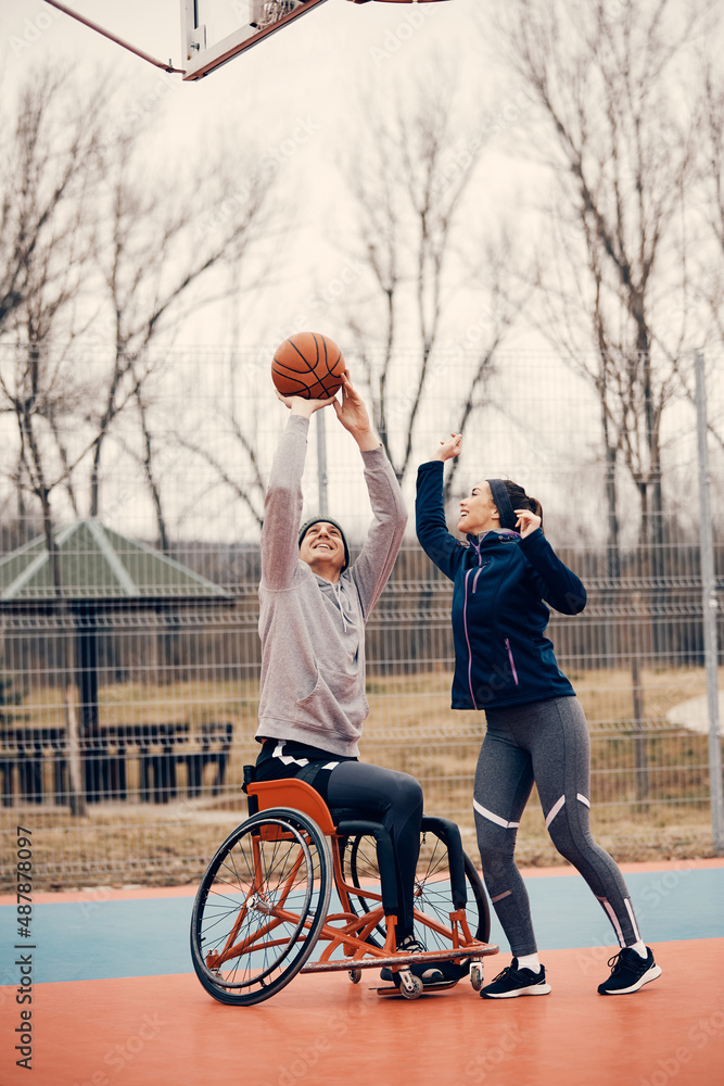 Athlete in wheelchair shooting at the hoop while playing basketball
