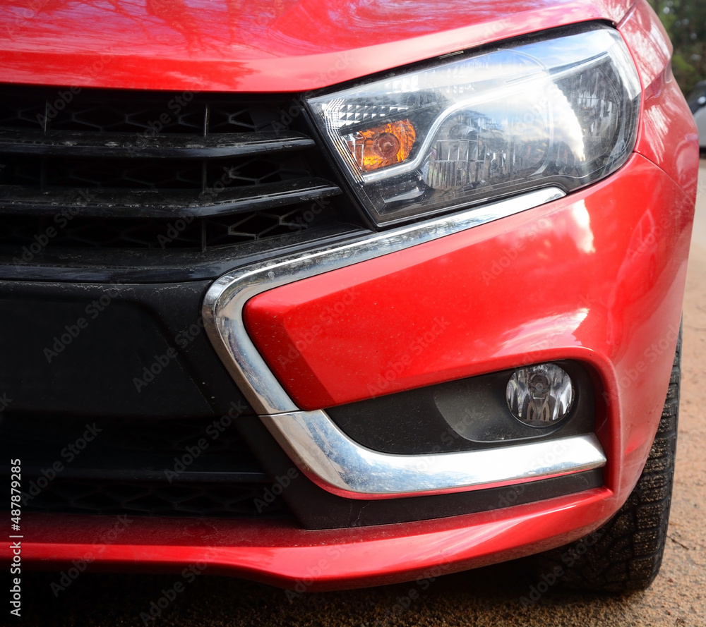 Part of the front of a red car as a background, close shot, Russian model