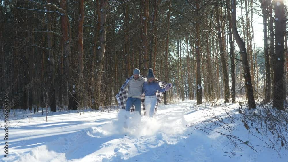 Happy couple running and having fun together in winter forest, Christmas holidays or valentine's day concept. Happy couple running and having fun together in winter forest, Christmas holidays or valentine's day concept.