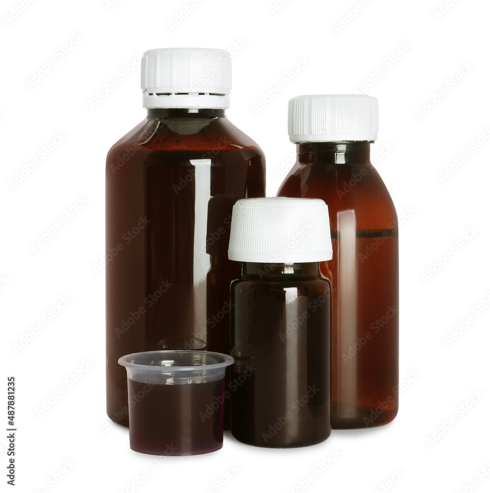Bottles of cough syrup and measuring cup on white background Bottles of cough syrup and measuring cup on white background
