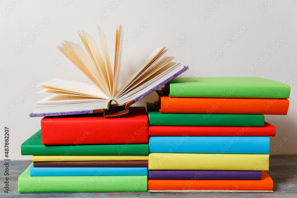 Fototapeta premium Opened Book on a pile of books