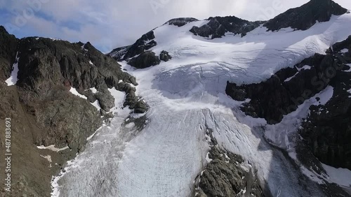 Alpine landscape. Aerial view of Glacier Vinciguerra in the rocky mountain peak. The white ice field and rocky cliffs. photo