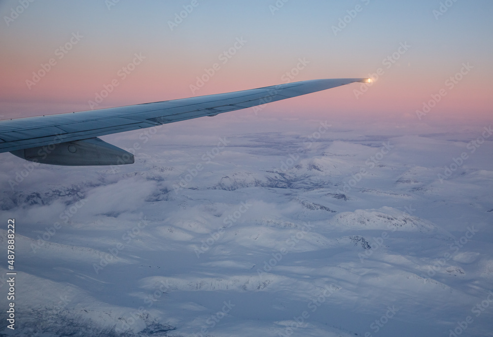 view from airplane window over a snow covered landscape view from airplane window over a snow covered landscape