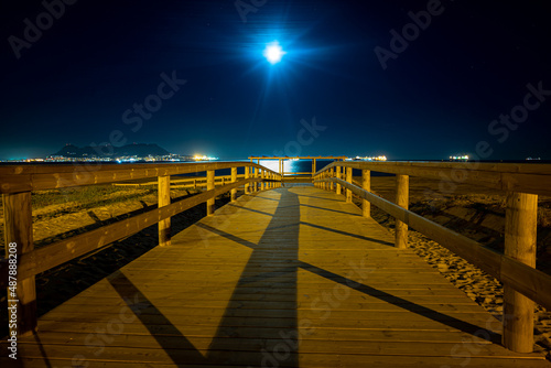 pasarela de madera en playa nocturna