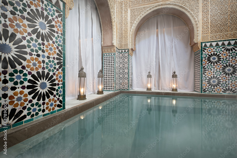 Steamy hot water bath in Arab baths with candle lamps under semicircular arches - obrazy, fototapety, plakaty 