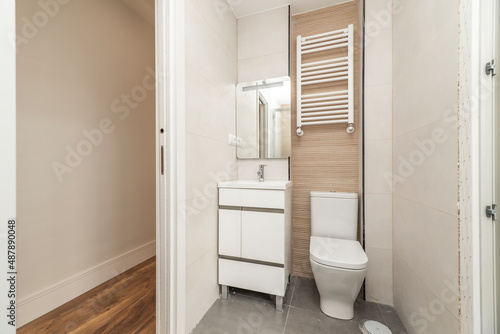 Bathroom with mirror, white sink cabinet, white towel radiator and wc