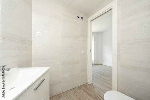 recently renovated bathroom with imitation marble tiles  wooden flooring and white wooden sink cabinet and china