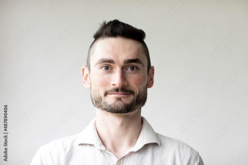 Young man with laptop in a room looking pleased Young man with laptop in a room looking pleased