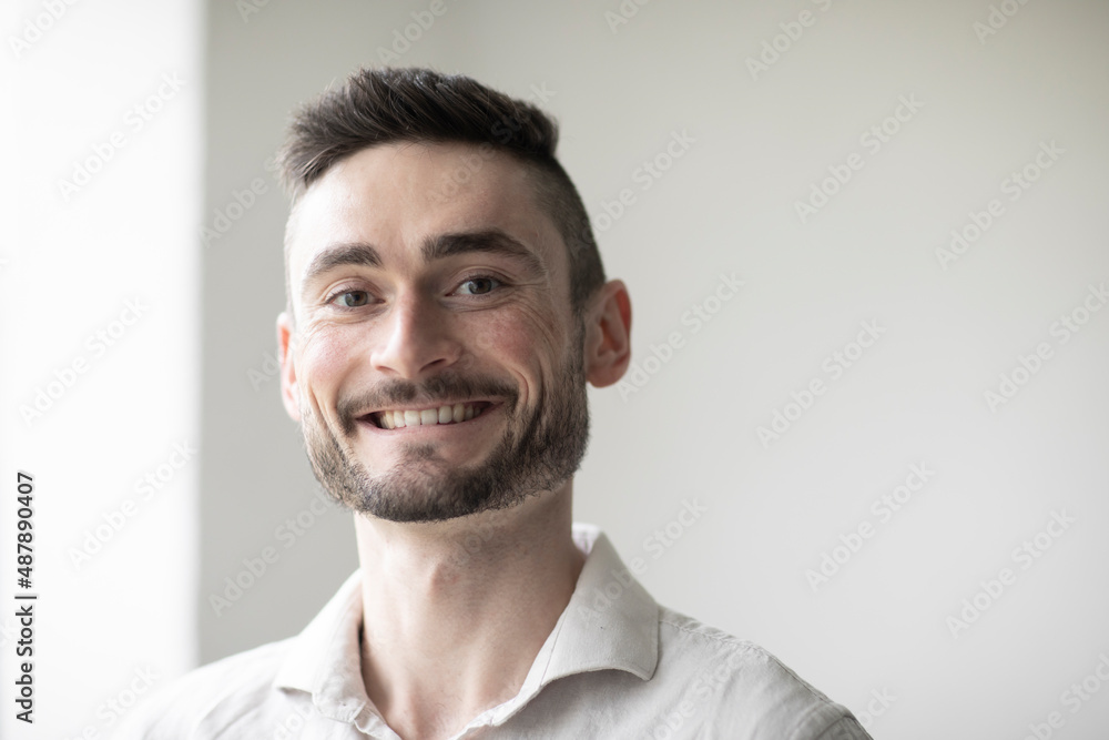 Young man with laptop in a room looking pleased Young man with laptop in a room looking pleased