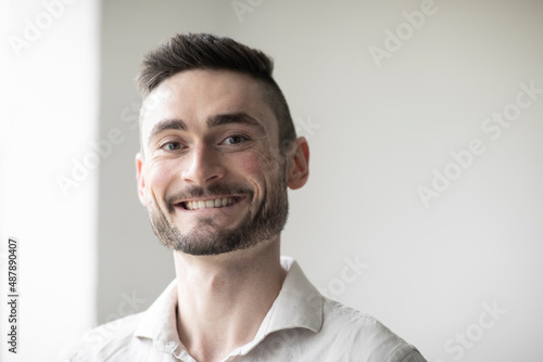 Young man with laptop in a room looking pleased
