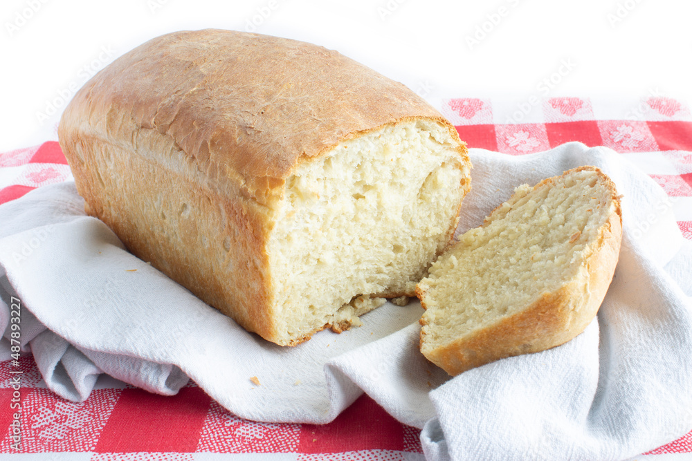 Fresh Bread with First Slice Taken out of it on Red and White Gingham Table Cloth