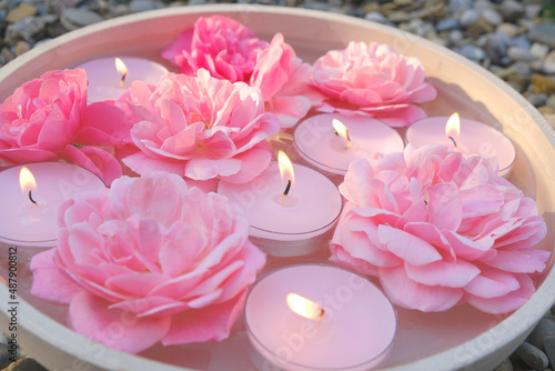 Rose candles.Pink candles and pink roses in water.Aromatherapy and spa concept.Candle flame. Candles background.Burning candles set