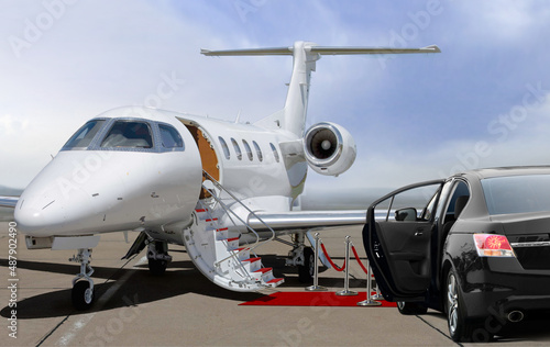 Private jet and black car waiting on landing strip in airport