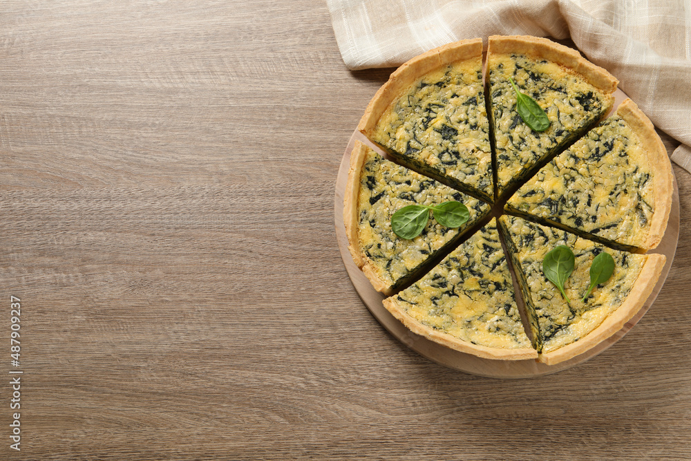 Cut delicious spinach pie on wooden table, top view. Space for text Cut delicious spinach pie on wooden table, top view. Space for text