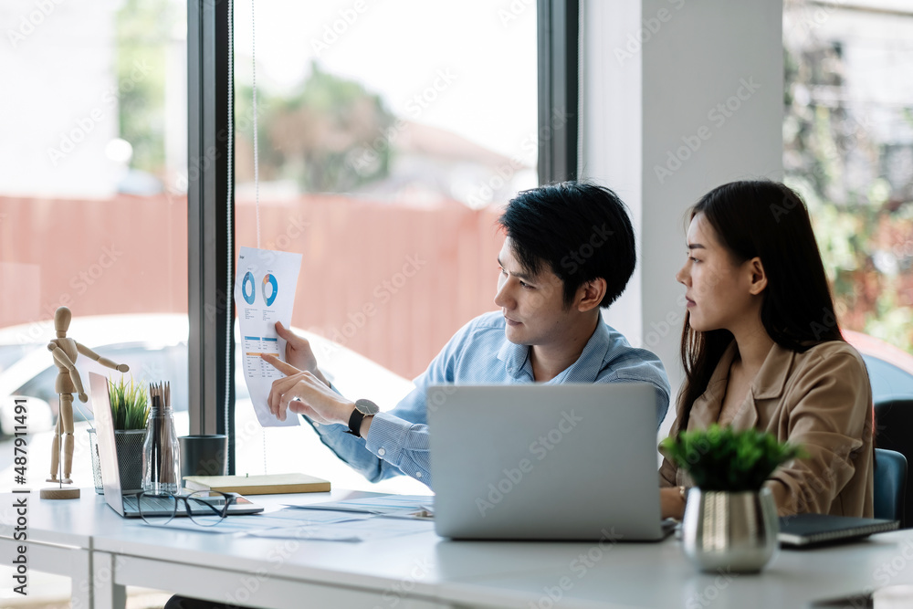 © Natee Meepian - Two business asian data dashboard analysis. Investment application display business sales and profit on paperwork and advise marketing planning decision.