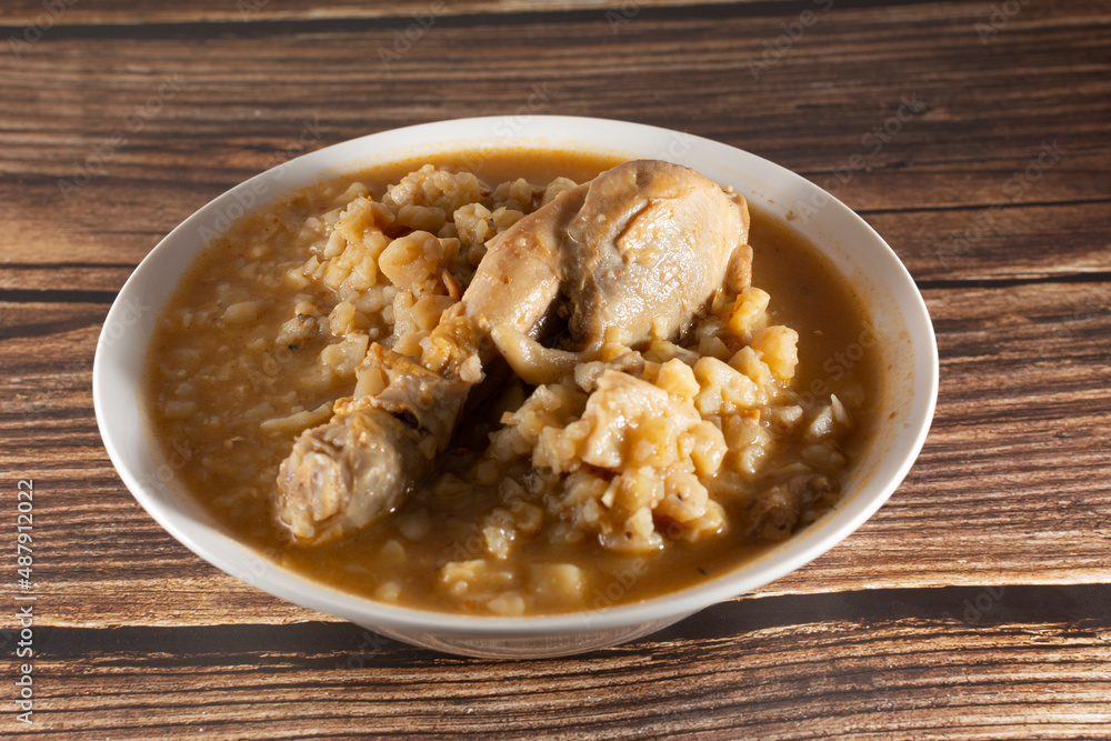 Chicken carapulcra (dry potato) in a deep plate on a wooden background Chicken carapulcra (dry potato) in a deep plate on a wooden background