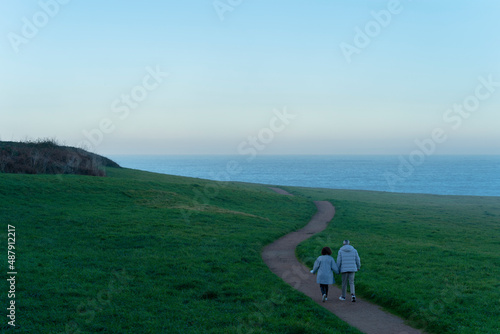 Older couple walking along a path near the sea of La Coruña Spain