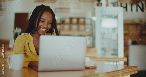 Successful young black woman working remotely in coffee shop on her laptop, success and diversity, future of remote work, young successful african american entrepreneur