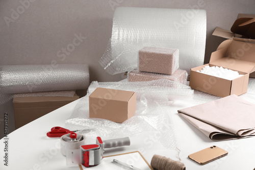 Obraz na płótnie Table with boxes, bubble wrap and packaging equipment in warehouse