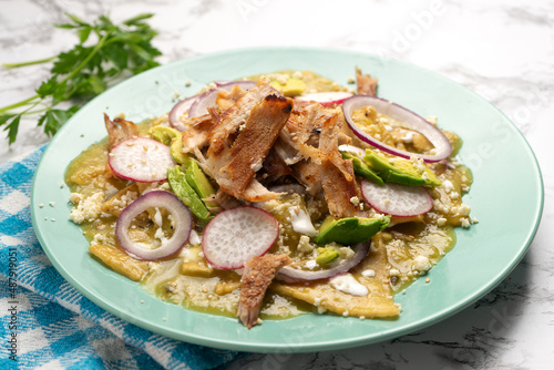 Green chilaquiles with pork meat and cheese. Mexican food