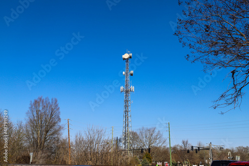 a tall gray radio tower surrounded by brown and bare winter trees with blue sky in Douglasville Georgia USA photo