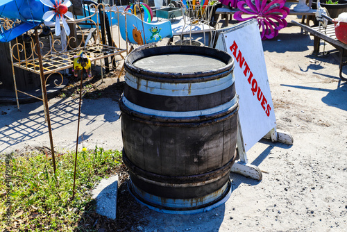 an old brown and white wood barrel next to a white and red antiques sign surrounded by various antiques in Douglasville Georgia USA photo