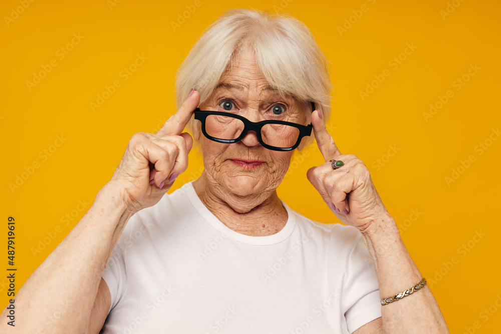 smiling elderly woman in a white t-shirt wears glasses cropped view smiling elderly woman in a white t-shirt wears glasses cropped view