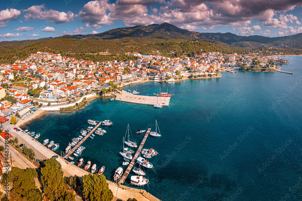 Wide aerial panoramic view of a resort sea town Neos Marmaras with yacht marina port in Halkidiki, Sithonia. Travel destinations and real estate in Greece