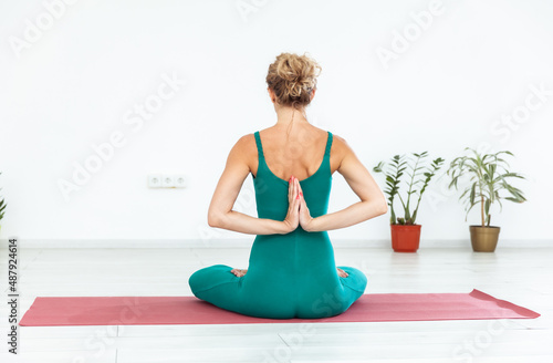 Yogi woman meditates. Hands in the namaste pose. Back view. Healthy lifestyle