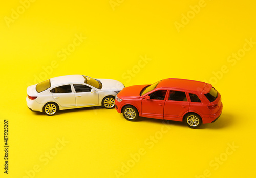 Fototapeta Naklejka Na Ścianę i Meble -  Two mini toy car crash on a yellow background, incident, car traffic accident
