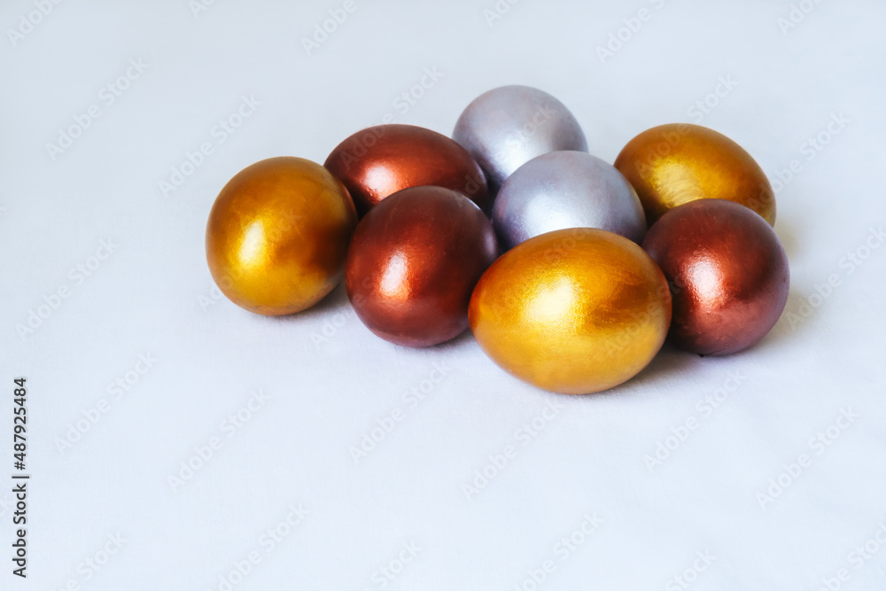 Festive Easter eggs in golden and silver colors on a white background. Festive Easter eggs in golden and silver colors on a white background.