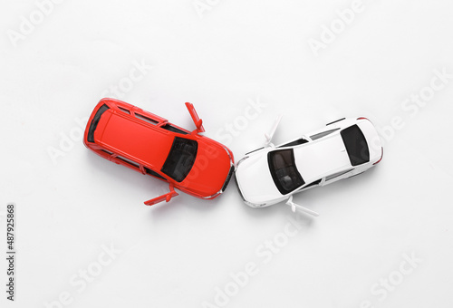 Two mini toy car crash on white background, incident, car traffic accident. Top view