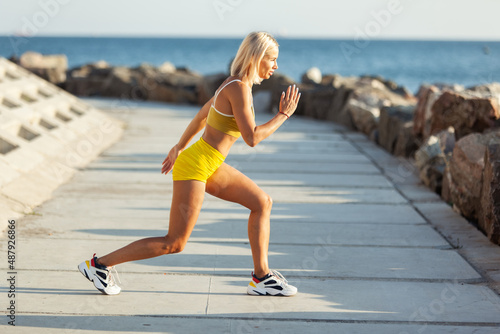 Young muscular fitness model exercising outdoors on a bright sunny day. Training on the beach. Healthy lifestyle © splitov27