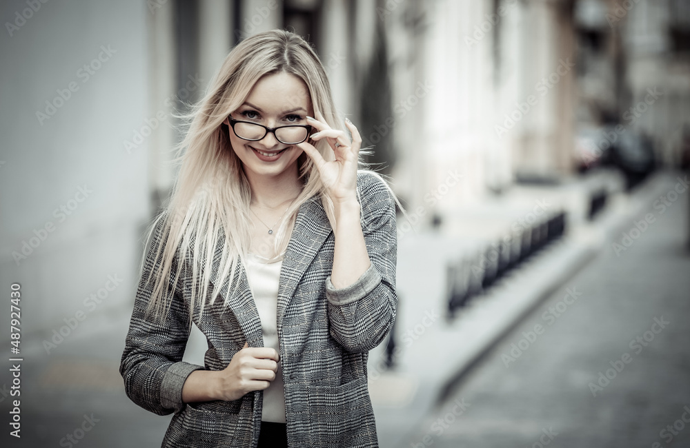 Portrait of a business woman in the city. Young blonde girl in business clothes