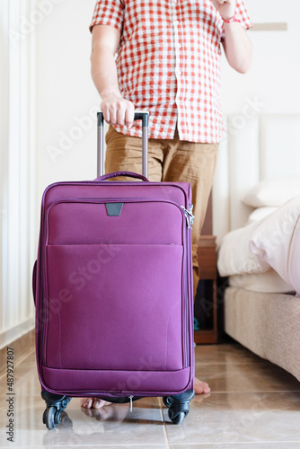 Handsome Caucasian young man packing his suitcase for travel