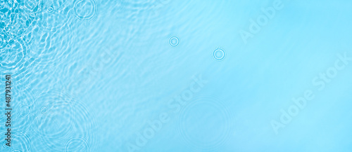 Transparent blue clear water surface texture with ripples, splashes and bubbles. Abstract summer banner background Water waves in sunlight with copy space Cosmetic moisturizer micellar toner emulsion © Aleksandra Konoplya