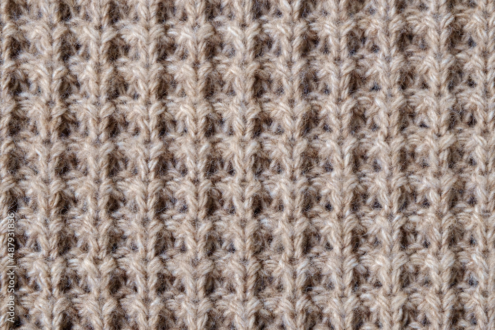 Texture of knitted woolen fabric of light brown color. Texture of knitted woolen fabric of light brown color.
