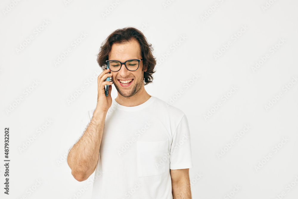 handsome man in a white T-shirt communication by phone isolated background handsome man in a white T-shirt communication by phone isolated background